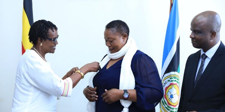 Ms. Winnie Byanyima giving the medal to Hon. Babalanda