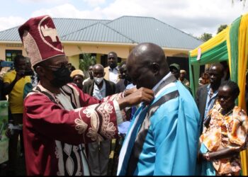 The Lango Paramount Chief(Won Nyaci)Eng. Dr Michael Moses Odongo Okune dresses one of the newly-installed clan chief(awitong)Willy Kagere Omodo-Omodo in a ceremony held at Akia in Lira City.