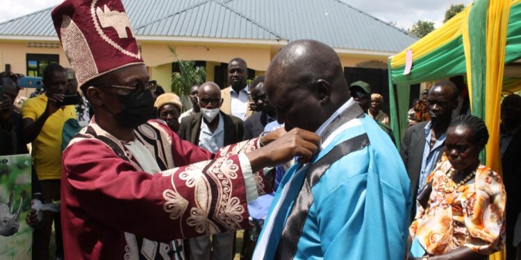 The Lango Paramount Chief(Won Nyaci)Eng. Dr Michael Moses Odongo Okune dresses one of the newly-installed clan chief(awitong)Willy Kagere Omodo-Omodo in a ceremony held at Akia in Lira City.