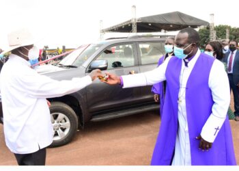 President Museveni handing over car keys to Bishop Moses  Odongo