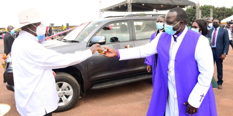 President Museveni handing over car keys to Bishop Moses  Odongo