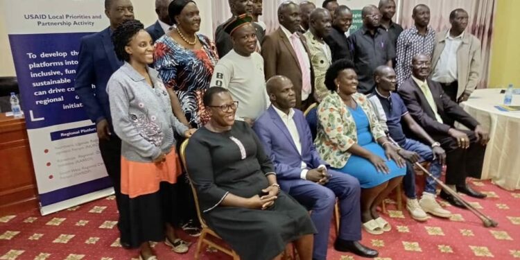 Karamoja Regional Development Initiative members are flanked by their regional members of parliament in a group photo at Kampala Hotel Africana on Thursday