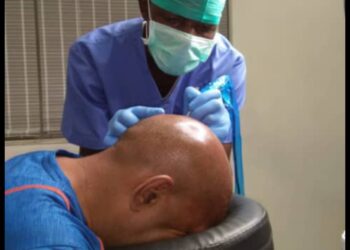 A Dermatologist set to start carrying out a scalp micro pigmentation procedure on a patient after preparing them fully for the session