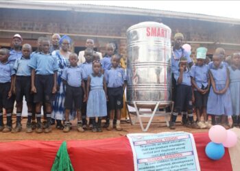 Kalerwe Parents School learners and other officials pose for a photo with the smart tank.