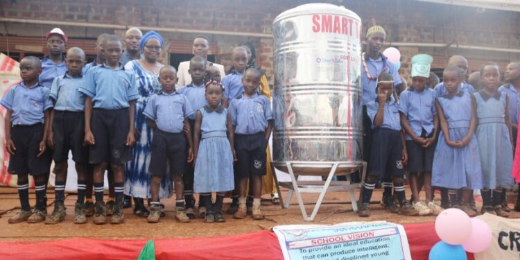 Kalerwe Parents School learners and other officials pose for a photo with the smart tank.