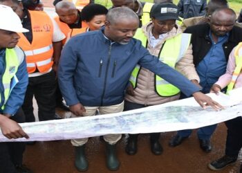 Tayebwa (C) being shown the design and layout of the Mpigi - Busega Expressway