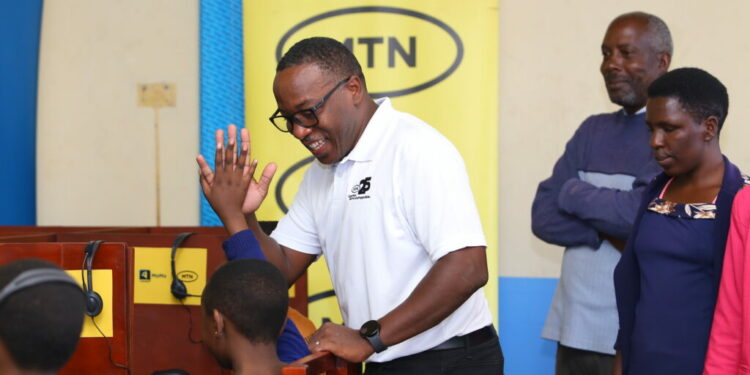 Brian-Mbasa-Senior-Manager-MTN-Foundation-talks-to-learners-of-Hornby-High-School-Junior-as-they-use-computers-courtesy-of-the-telecom-comapny-to-stir-digital-skills-among-learners