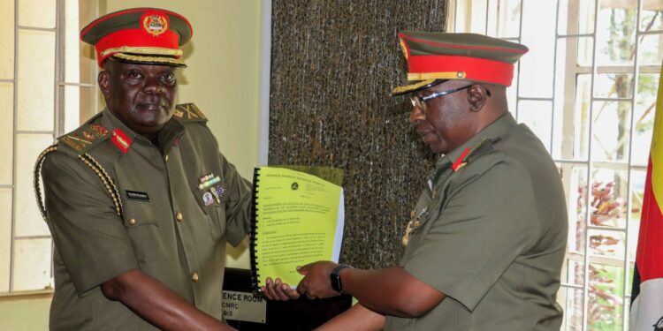 Brig-Gen-Godwin-Karugaba-L-receives-a-report-from-Brig-Gen-Charles-Bakahumara