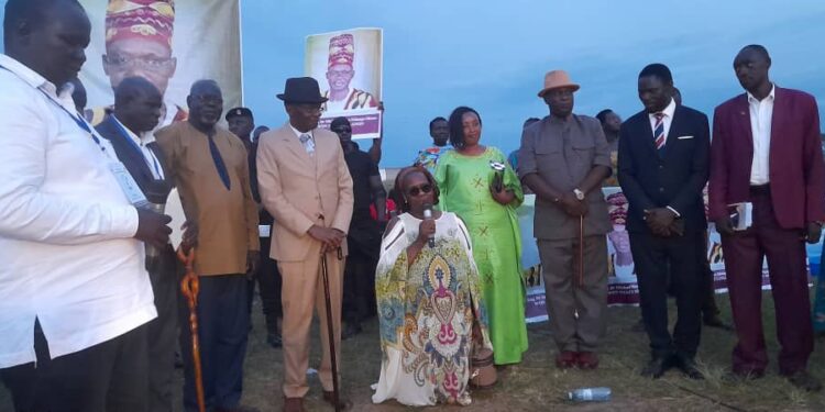 The Won Nyaci- elect HRH Eng Dr Michael Moses Odongo Okune (M) looks on as wife Min-Bangi Margaret Odongo kneels to thank the audience and pledges to serve as Mother of all people of Lango following the election