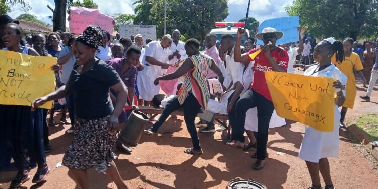 Some female health workers dance provocatively flashing their backs and thighs to the DPC Innocent Mubangizi.