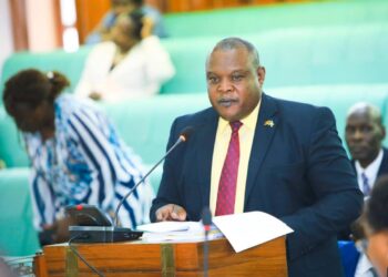 Hon. Tonny Ayoo, presenting the committee report to Parliament