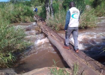 A journalist crossing Nyagak Paa Bruno footbridge that connects Atyak Sub-County  and Nebbi Subcounty recently. The footbridge is reported to have claimed more than 20 lives since  2007.PHOTO/MIKE RWOTHOMIO.