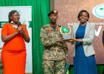Maj. Gen Sabiiti Muzeeyi. General Manager - Luwero Industries Ltd. NEC, handing over the award to Barbara Dokoria (R) the Stanbic Bank Ag. Executive Director, Looking is Diana Ondoga the bank's head of CS