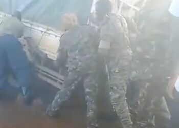 Some of the soldiers trying to move a vehicle stuck in the muddy swamp