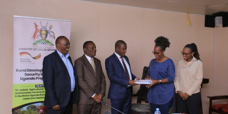 Hajj Sewante handing over the contract to Gloria Sibo Muhwezi of Gesch Consult