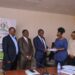 Hajj Sewante handing over the contract to Gloria Sibo Muhwezi of Gesch Consult