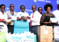 Diana-Ondoga-Stanbic-Bank-Manager-Corporate-Social-Investment-shaking-hands-with-Dr.-Henry-Ddungu-of-Uganda-Cancer-Institute.-Looking-on-Afrigos-Rachael-Magola-scaled.jpg