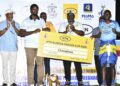 Kyabazinga of Busoga William Gabula Nadiope IV handing over the cheque to Kigulu FC team captain after defeating Luuka FC in finals of the 8th edition of the MTN-Busoga Masaza Cup at Bugembe stadium.