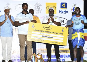Kyabazinga of Busoga William Gabula Nadiope IV handing over the cheque to Kigulu FC team captain after defeating Luuka FC in finals of the 8th edition of the MTN-Busoga Masaza Cup at Bugembe stadium.