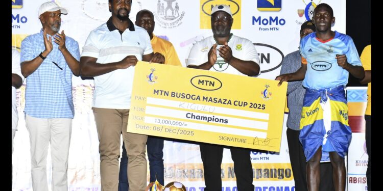 Kyabazinga of Busoga William Gabula Nadiope IV handing over the cheque to Kigulu FC team captain after defeating Luuka FC in finals of the 8th edition of the MTN-Busoga Masaza Cup at Bugembe stadium.