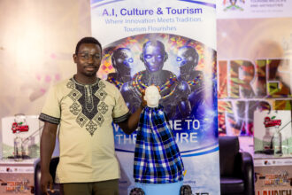 Jonathan Ssemakula, founder of Zunobotics, stands beside his AI-powered robot “Okello,” showcasing innovation at the launch of Miss Tourism Uganda 2026.