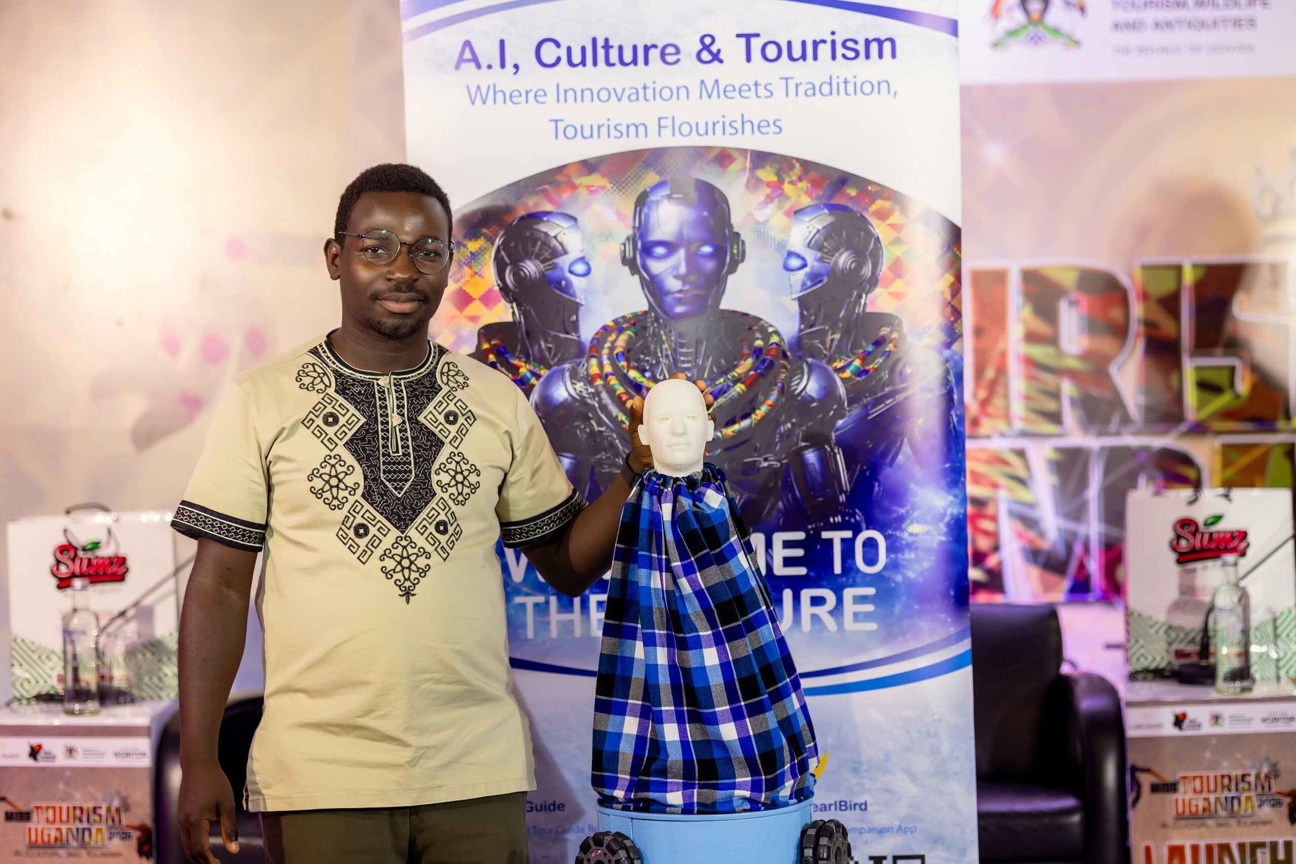 Jonathan Ssemakula, founder of Zunobotics, stands beside his AI-powered robot “Okello,” showcasing innovation at the launch of Miss Tourism Uganda 2026.